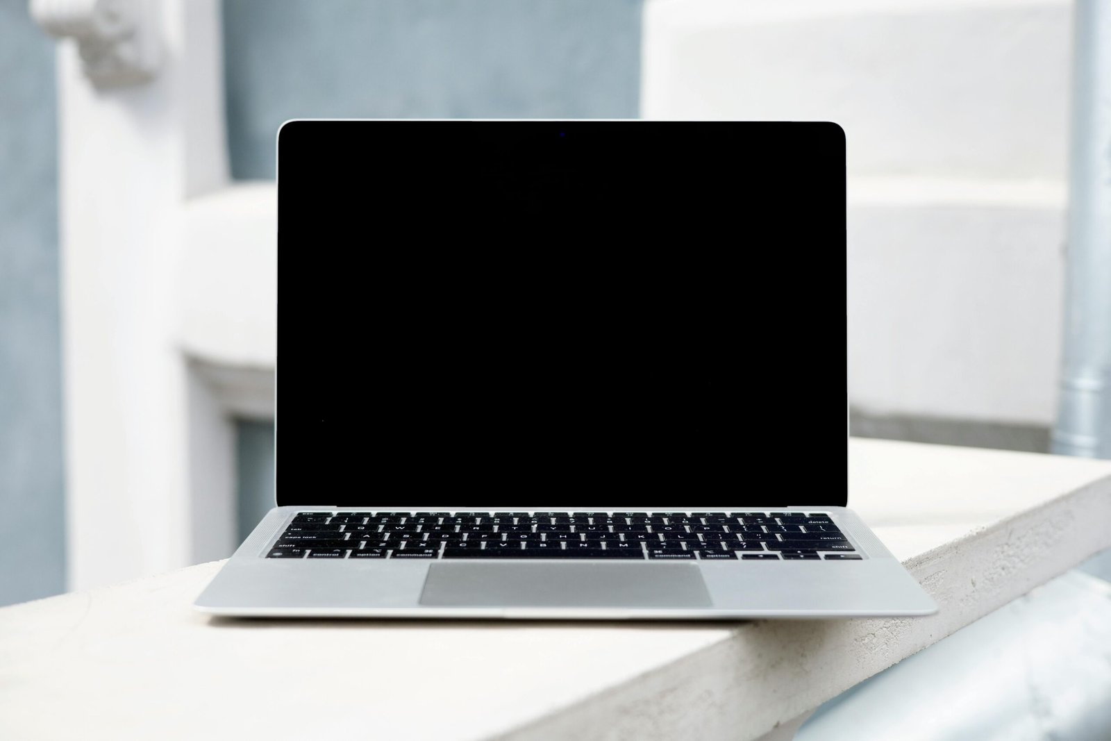 A sleek laptop with a blank screen on a white surface, perfect for digital mockups.